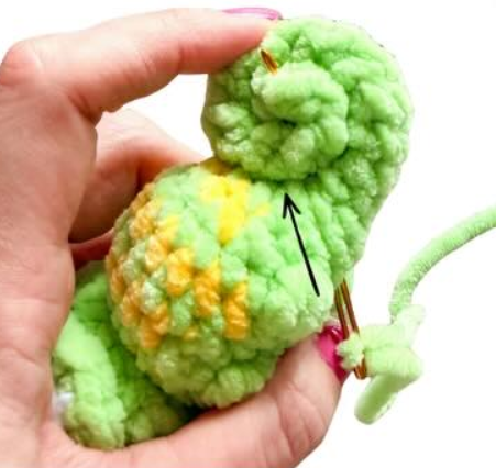 Place a 10'' strand of green yarn on a darning needle
